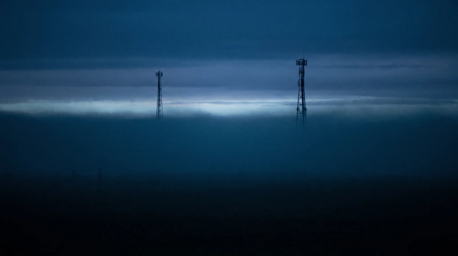 Telecom towers silhouetted in evening haze